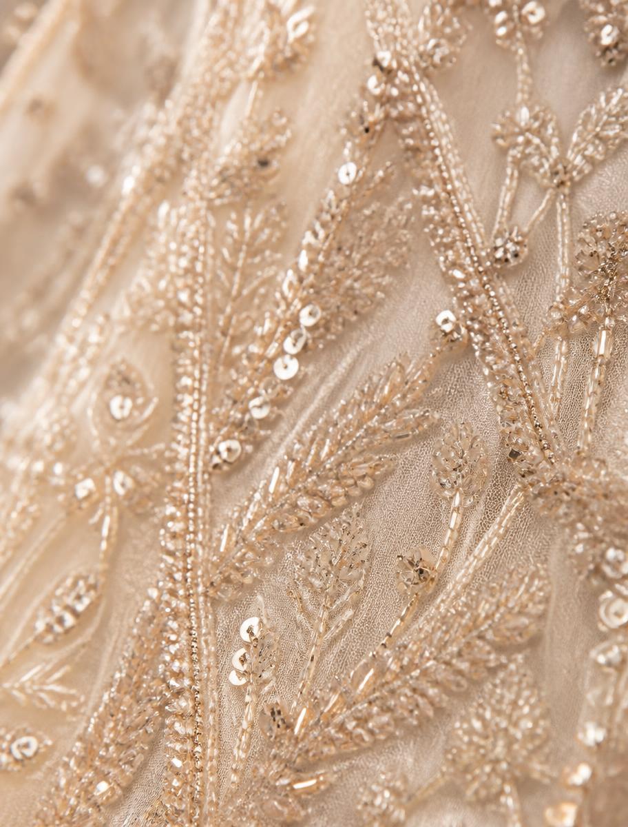 Close detail of hand-beaded champagne gown fabric